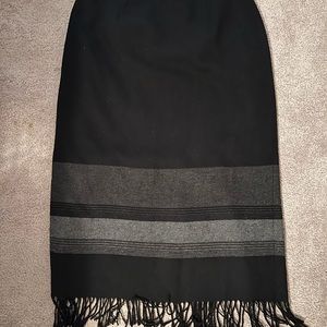 Fully lined black, long wool skirt with gray stripes and fringe on the bottom.